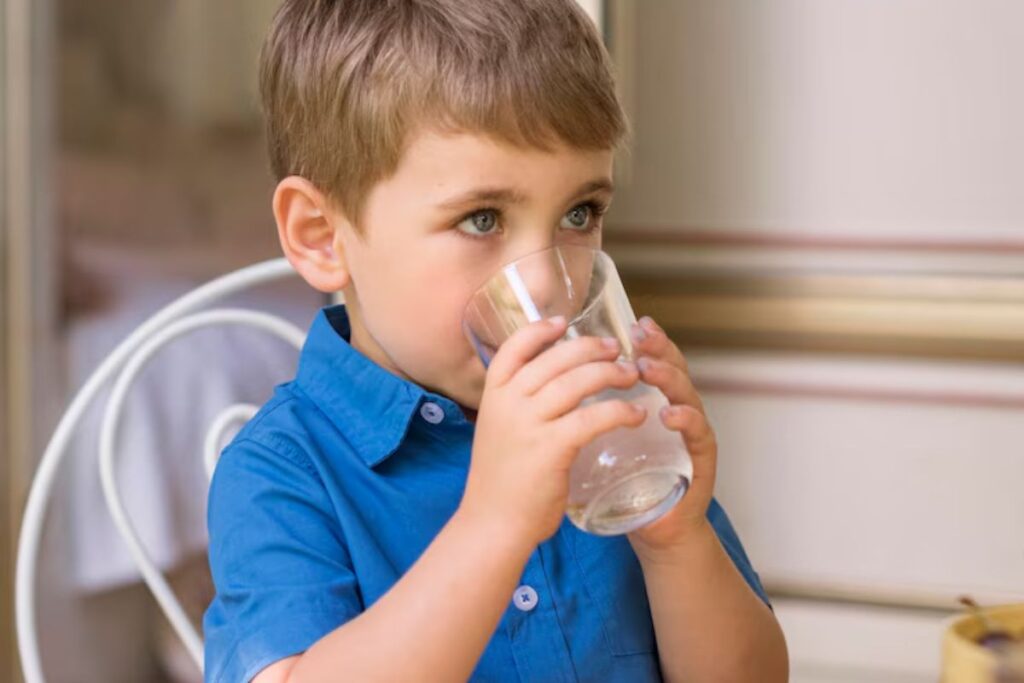 a child in Dallas drinking water from a glass- pediatric dentist in Dallas